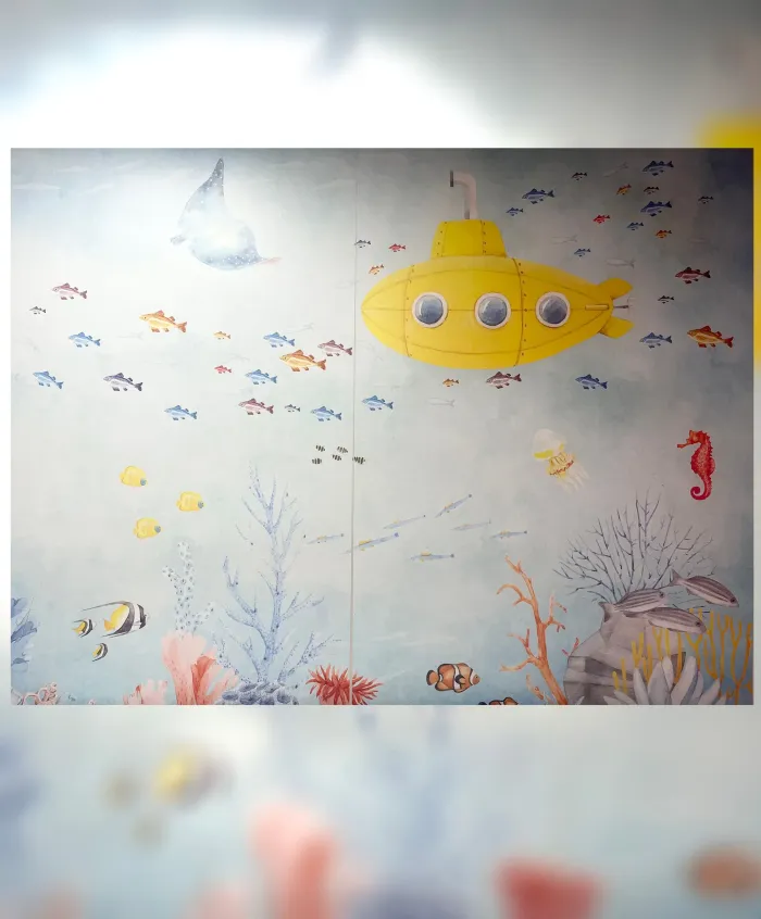 Wall mural of a yellow submarine among colorful fish
