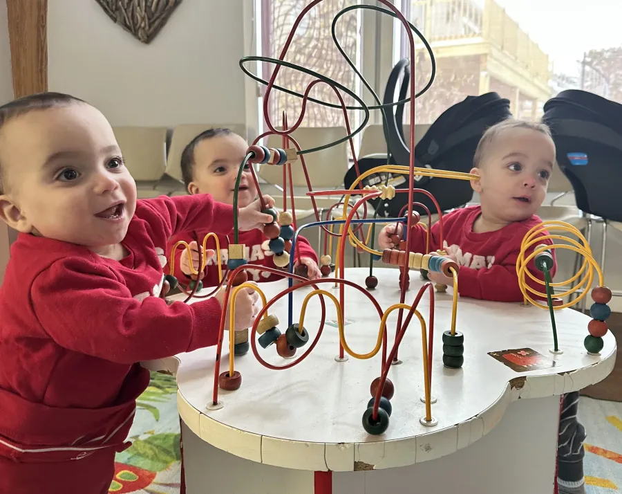 Toddlers playing with a bead maze toy
